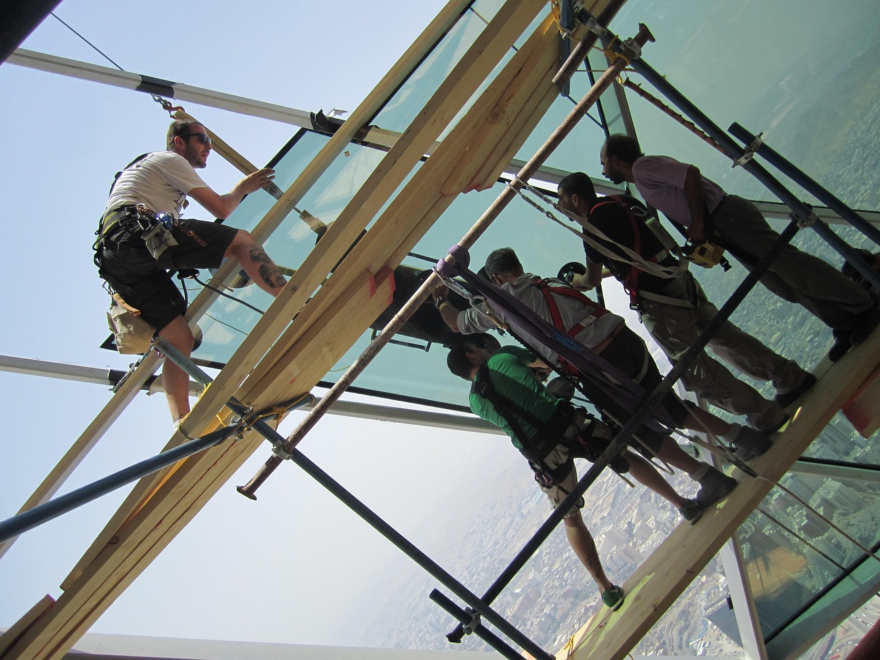 saudi arabia, men, building, structure, mounting glass, panel, panels, dangerous, high, working, nature, replacing, sky, clouds, outside